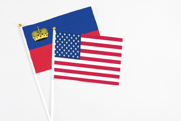 United States and Liechtenstein stick flags on white background. High quality fabric, miniature national flag. Peaceful global concept.White floor for copy space.