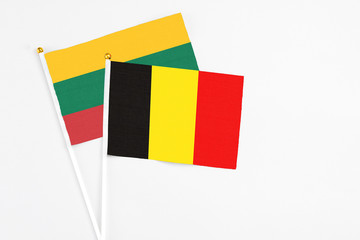 Belgium and Lithuania stick flags on white background. High quality fabric, miniature national flag. Peaceful global concept.White floor for copy space.