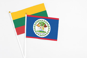 Belize and Lithuania stick flags on white background. High quality fabric, miniature national flag. Peaceful global concept.White floor for copy space.