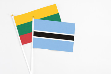 Botswana and Lithuania stick flags on white background. High quality fabric, miniature national flag. Peaceful global concept.White floor for copy space.