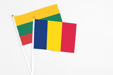 Chad and Lithuania stick flags on white background. High quality fabric, miniature national flag. Peaceful global concept.White floor for copy space.