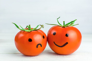 Relationship. emotions on tomatoes. smile and sad.