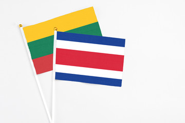 Costa Rica and Lithuania stick flags on white background. High quality fabric, miniature national flag. Peaceful global concept.White floor for copy space.