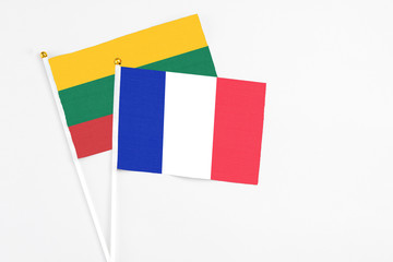 Fototapeta na wymiar France and Lithuania stick flags on white background. High quality fabric, miniature national flag. Peaceful global concept.White floor for copy space.