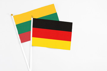 Germany and Lithuania stick flags on white background. High quality fabric, miniature national flag. Peaceful global concept.White floor for copy space.
