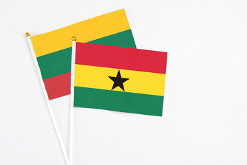 Ghana and Lithuania stick flags on white background. High quality fabric, miniature national flag. Peaceful global concept.White floor for copy space.