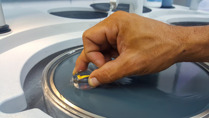 Laboratory staff is preparing metal surface by polished before acid etching and analyze metal structure with microscope
