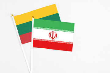 Iran and Lithuania stick flags on white background. High quality fabric, miniature national flag. Peaceful global concept.White floor for copy space.