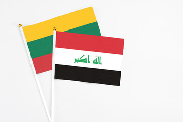 Iraq and Lithuania stick flags on white background. High quality fabric, miniature national flag. Peaceful global concept.White floor for copy space.