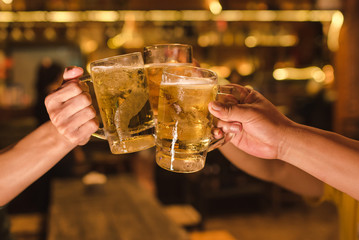 Three friends drink beer happily and friendship in the pub.