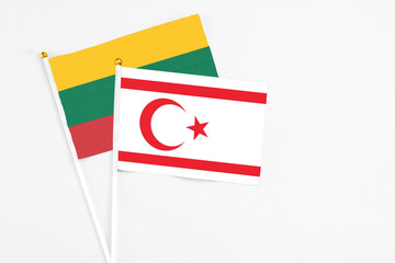 Northern Cyprus and Lithuania stick flags on white background. High quality fabric, miniature national flag. Peaceful global concept.White floor for copy space.