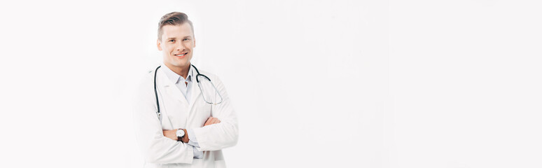 panoramic shot of smiling doctor in white coat standing with crossed arms isolated on white