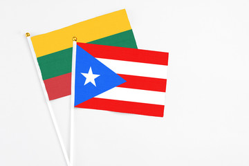 Puerto Rico and Lithuania stick flags on white background. High quality fabric, miniature national flag. Peaceful global concept.White floor for copy space.