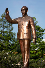 Recently polished bronze statue of Ho Chi Minh standing in the famous walking street in Ho Chi Minh City. The building behind him is a Classic of the French Colonial architecture of the city