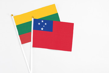 Samoa and Lithuania stick flags on white background. High quality fabric, miniature national flag. Peaceful global concept.White floor for copy space.