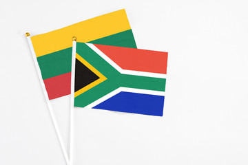 South Africa and Lithuania stick flags on white background. High quality fabric, miniature national flag. Peaceful global concept.White floor for copy space.