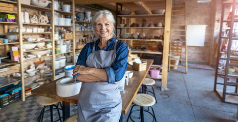 Portrait of senior female pottery artist in her art studio