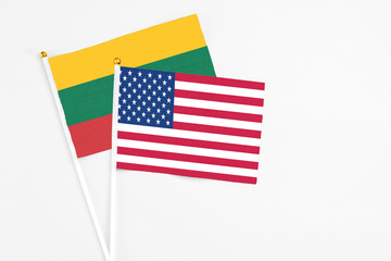 United States and Lithuania stick flags on white background. High quality fabric, miniature national flag. Peaceful global concept.White floor for copy space.