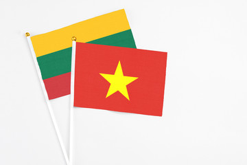 Vietnam and Lithuania stick flags on white background. High quality fabric, miniature national flag. Peaceful global concept.White floor for copy space.