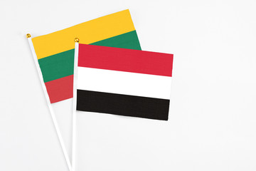 Yemen and Lithuania stick flags on white background. High quality fabric, miniature national flag. Peaceful global concept.White floor for copy space.