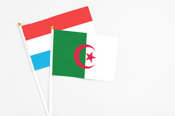 Algeria and Luxembourg stick flags on white background. High quality fabric, miniature national...