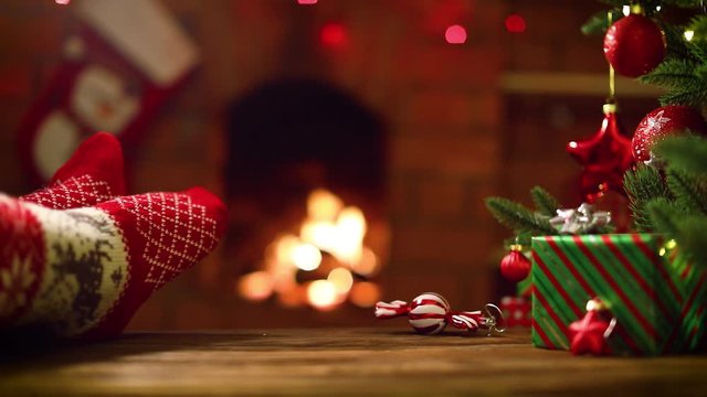 Feet in Woollen Socks by the Christmas Fireplace. Winter and Christmas Holidays Concept