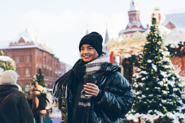 Fototapeta premium Happy woman standing on street with takeaway coffee