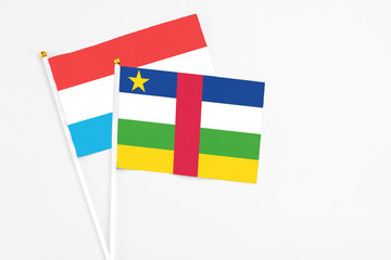 Central African Republic and Luxembourg stick flags on white background. High quality fabric, miniature national flag. Peaceful global concept.White floor for copy space.