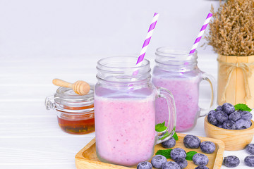 Obraz na płótnie Canvas Blueberry Juice smoothies drink in a glass drink purple colorful fruit juice milkshake blend beverage healthy high protein the taste yummy in glass on white wood background.