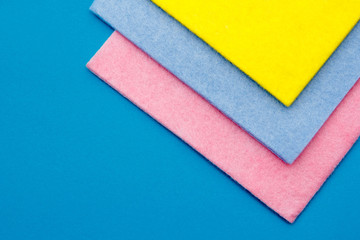 Multicolored cleaning rags on blue background. Cleaning cloth. The view from the top. Copy, empty space for text