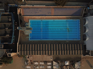 vue aérienne en top shot d'une piscine olympique vide avec gradins et à ciel ouvert pendant le lever du soleil