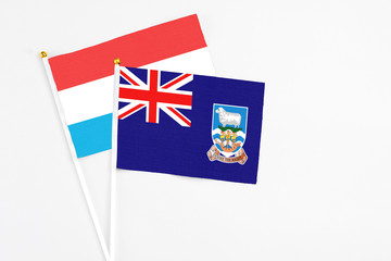 Falkland Islands and Luxembourg stick flags on white background. High quality fabric, miniature...