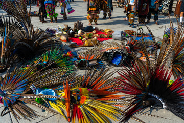 Los danzantes están descansando y dejaron sus penachos y sus instrumentos musicales en el suelo...