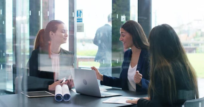4K Happy enthusiastic businesswomen laughing & giving high 5s in a meeting. Slow motion.