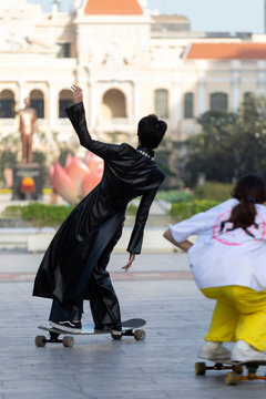 Stylish Girl Skater In Black Gothic Outfit And French Colonial Architecture In The Walking Street Of Ho Chi Minh City Vietnam