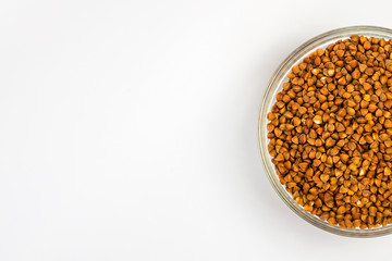 Buckwheat groats in a plate on a white background. Buckwheat porridge in a small plate. Diet breakfast. Healthy food.