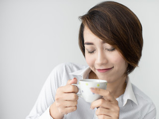Businesswoman drinking coffee and looking out window.