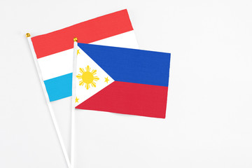 Philippines and Luxembourg stick flags on white background. High quality fabric, miniature national flag. Peaceful global concept.White floor for copy space.