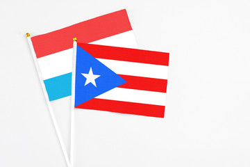 Puerto Rico and Luxembourg stick flags on white background. High quality fabric, miniature national flag. Peaceful global concept.White floor for copy space.