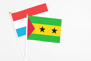 Sao Tome And Principe and Luxembourg stick flags on white background. High quality fabric, miniature national flag. Peaceful global concept.White floor for copy space.