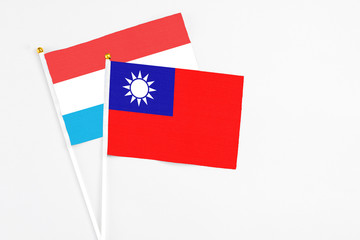 Taiwan and Luxembourg stick flags on white background. High quality fabric, miniature national flag. Peaceful global concept.White floor for copy space.