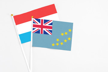 Tuvalu and Luxembourg stick flags on white background. High quality fabric, miniature national...