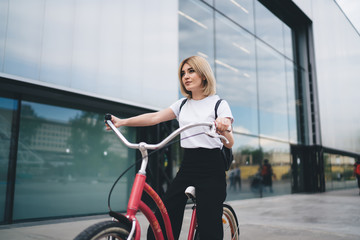 Fototapeta na wymiar Confident modern female on pink bicycle