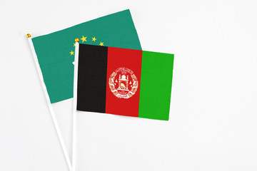 Afghanistan and Macao stick flags on white background. High quality fabric, miniature national flag. Peaceful global concept.White floor for copy space.