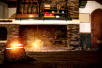 Christmas candles with fire on top of board.Free space for your decoration.Xmas time in home of the hunter's house.Big retro fireplace and american hunter rifles on a stand.Copy space and mood photo.