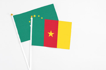 Cameroon and Macao stick flags on white background. High quality fabric, miniature national flag. Peaceful global concept.White floor for copy space.