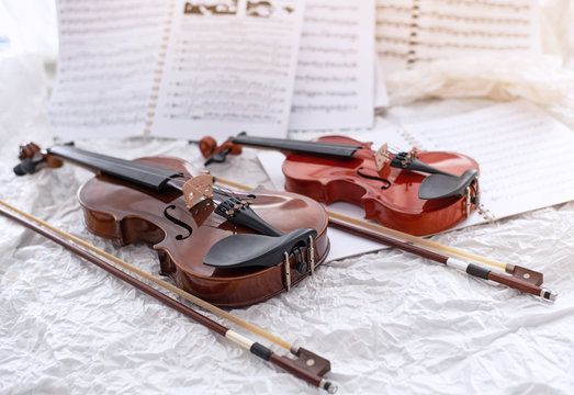 The wooden violin and bow put on grunge surface background,vintage and art tone,blurry light around
