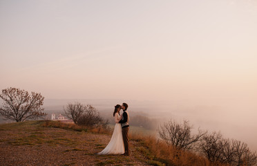 Romantic couple on the background of the rising sun. Fog. hugging. parting concept. anxiety. frame from the movie. the actors