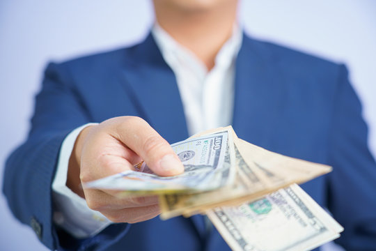 Business man and money in us dollar hold on hand wearing a blue suit and Give to me USD, Pay, exchange money vietnamese on white background.