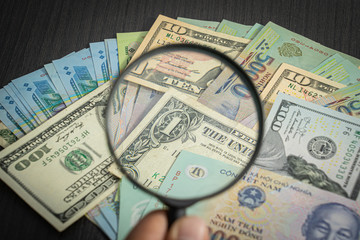 all money stack US dollar USD, VND, dong Pay, exchange  vietnamese and Magnifying glasson looking at numbers background.